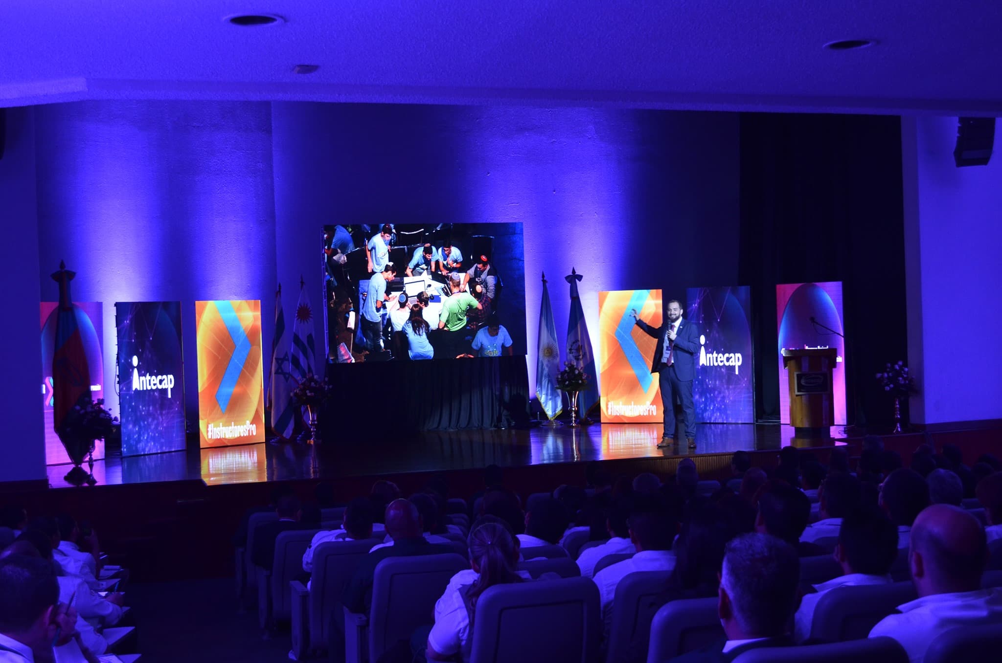 Damian Filut presenting on stage at the INTECAP Congress, Guatemala